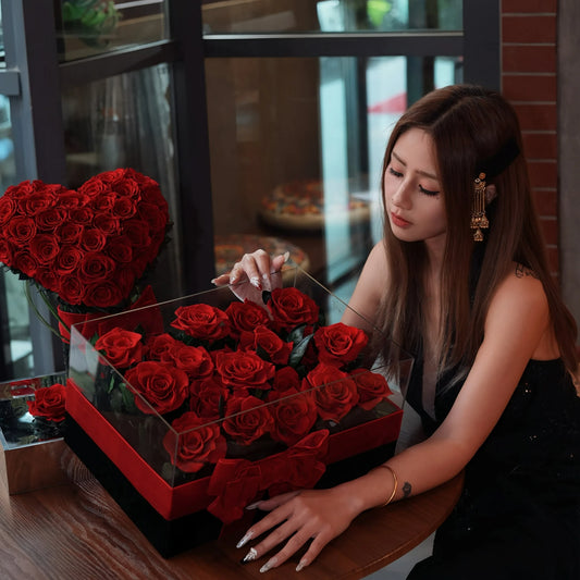 LULU ROSÉE Eternal Rose Garden 19 Roses and Heart Bouquet with Model at Restaurant Table