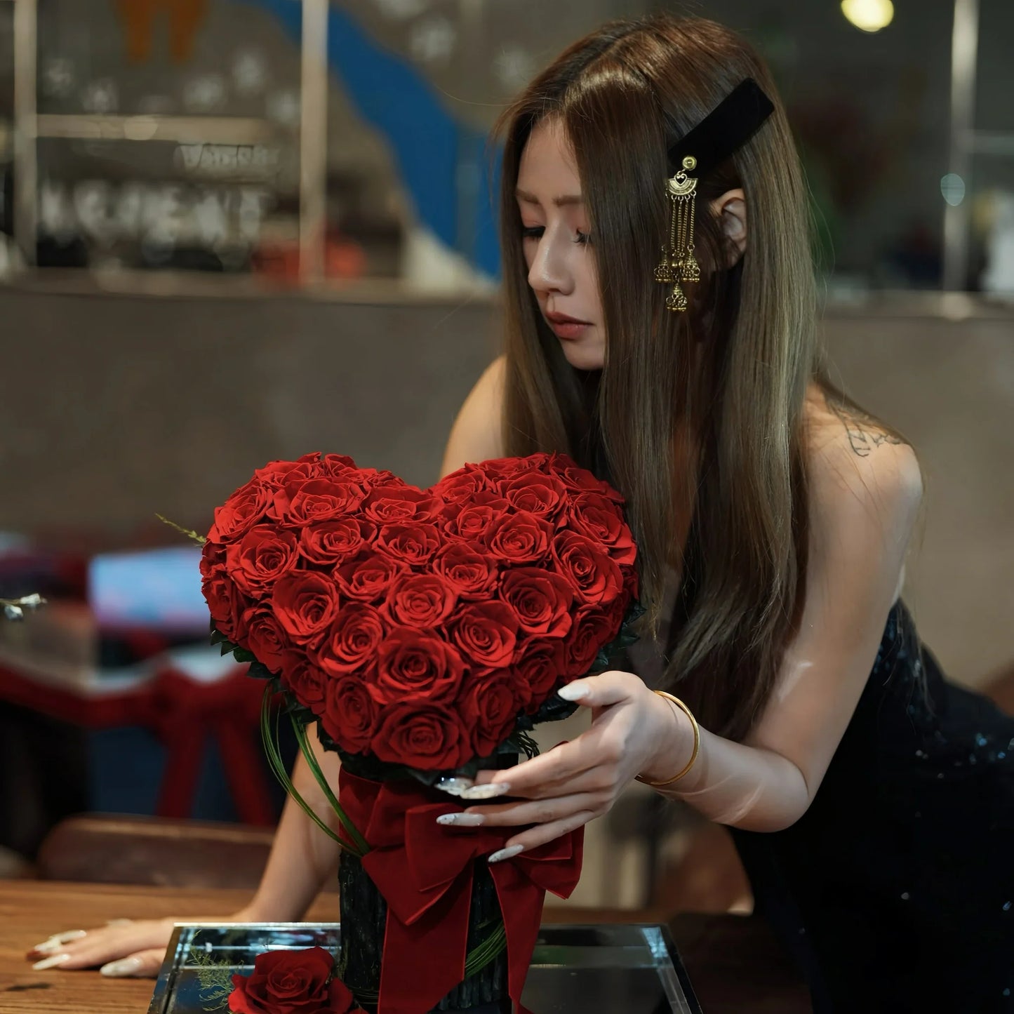 LULU ROSÉE Eternal Rose Garden Heart Bouquet Held by Model, 3D Red Roses in Vase with Red Bow