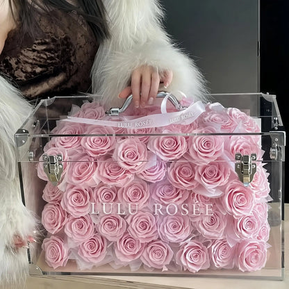 LULU ROSÉE Grande Eternal Acrylic Handbag Rose Box, luxury handbag-shaped transparent acrylic gift box filled with blush pink preserved roses, decorated with delicate satin bow ribbon, customizable flower colors, romantic everlasting floral souvenir for anniversary & birthday gifting