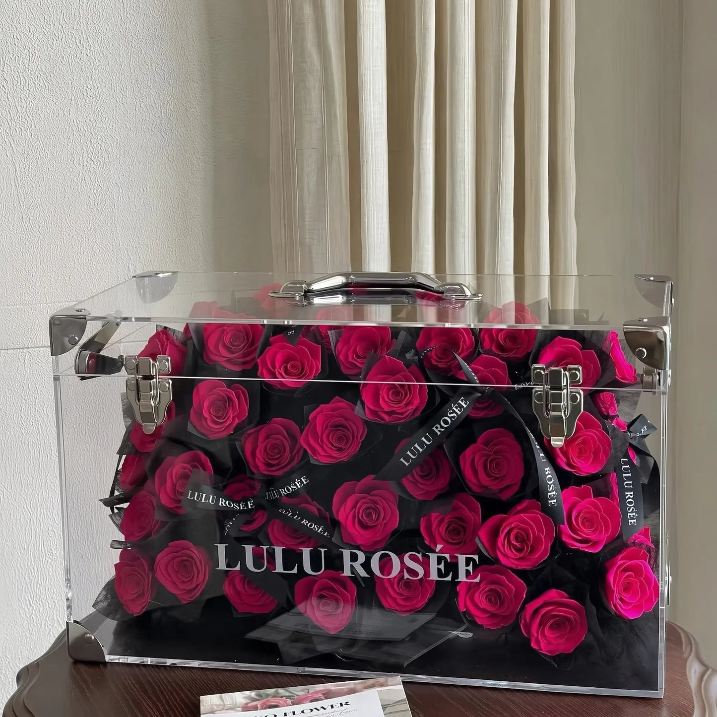 LULU ROSÉE Grande Eternal Acrylic Handbag Rose Box, luxury handbag-shaped transparent acrylic gift box filled with rosy preserved roses, elegant indoor background shot, customizable flower colors, romantic everlasting floral souvenir for anniversary & birthday gifting