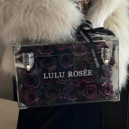 LULU ROSÉE Moyenne Eternal Acrylic Handbag Rose Box, medium transparent acrylic handbag-shaped gift box filled with dark purple preserved roses minimalist indoor shot, customizable flower colors, elegant everlasting floral gift for birthdays, anniversaries & romantic celebrations