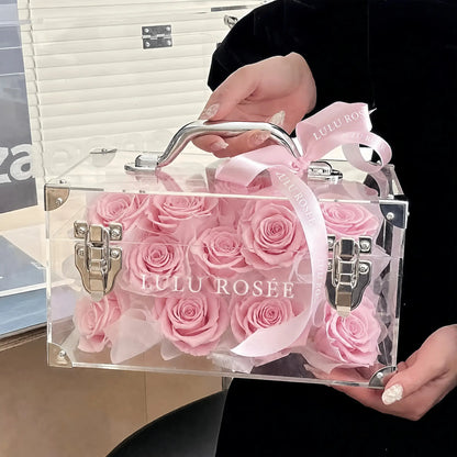 LULU ROSÉE Petite Eternal Acrylic Handbag Rose Box, small transparent acrylic handbag-shaped gift box filled with blush pink preserved roses decorated with pink satin bow, full front display shot, customizable flower color options, mini luxury everlasting floral souvenir for birthday, anniversary & romantic gift giving